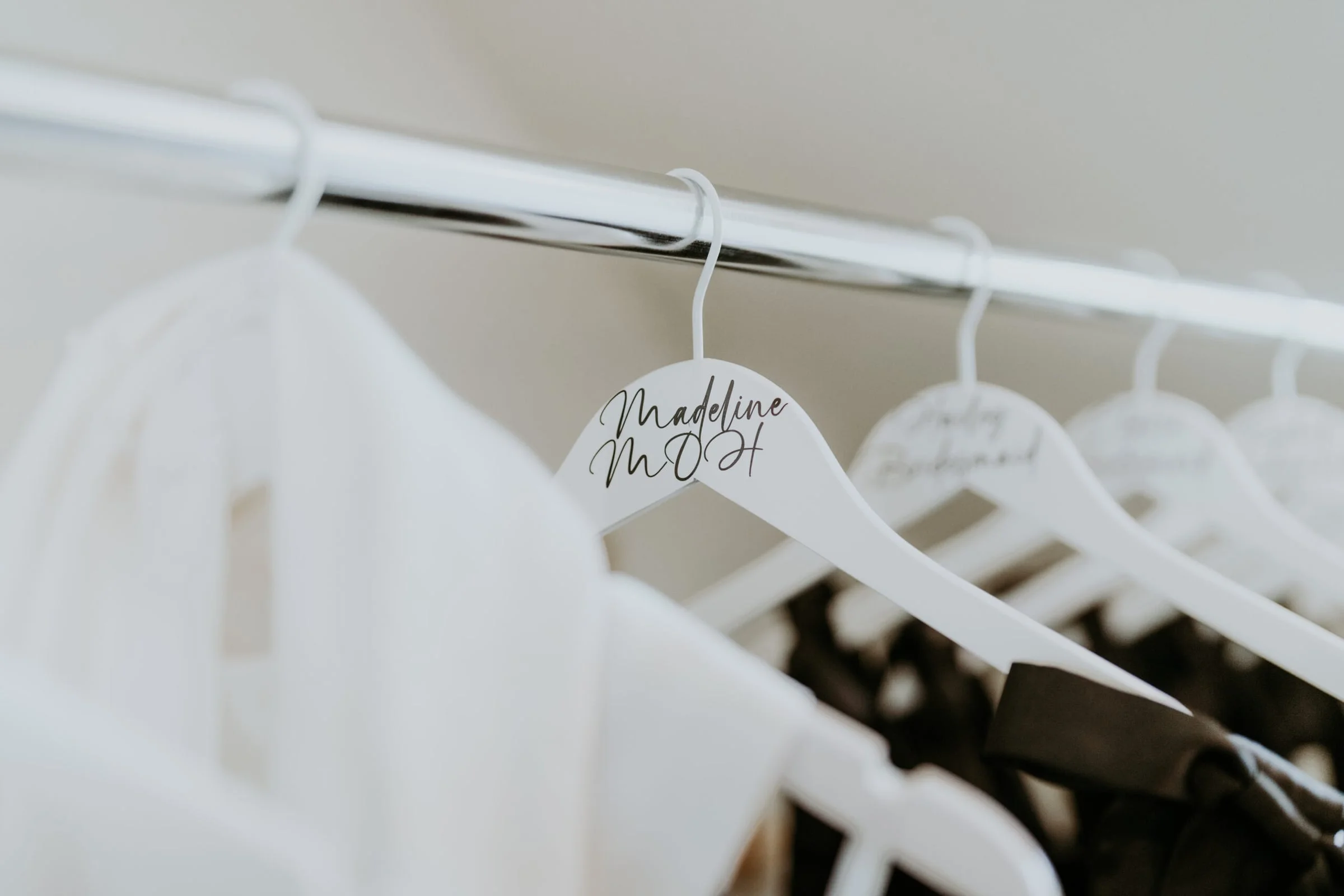 Wedding dresses hanging on a rail with personalized bridal hangers.