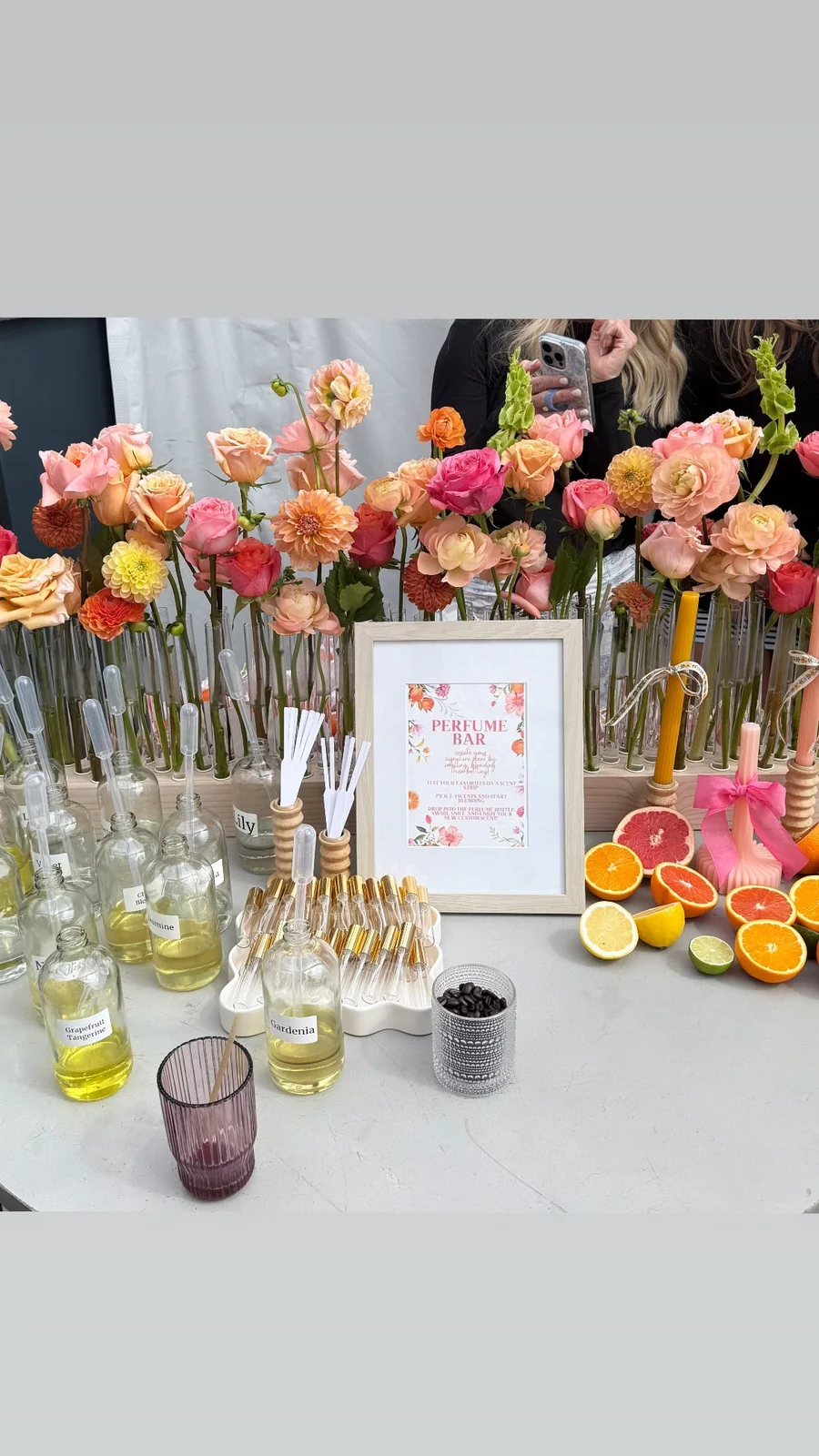 Spring brunch table with colorful flowers in vases, citrus slices and a framed menu