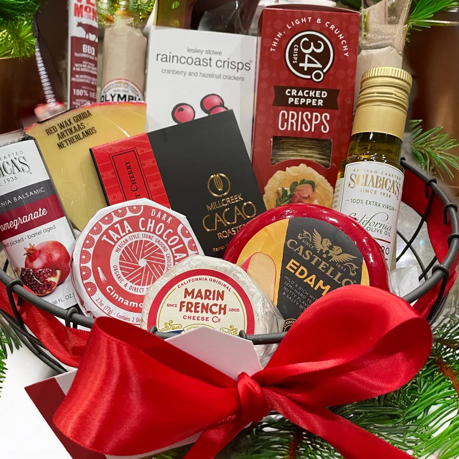Gift basket of gourmet cheeses, crackers and treats tied with a red bow