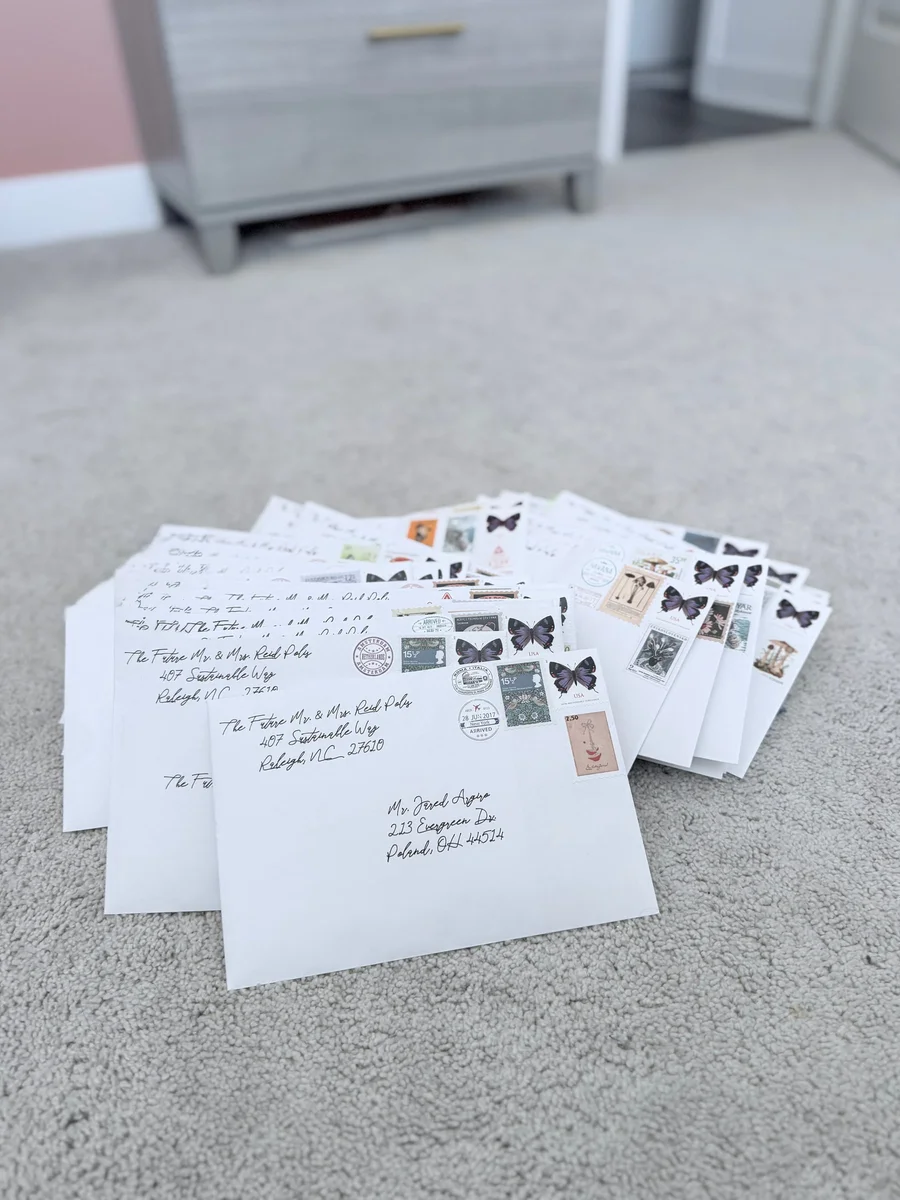 Stack of addressed envelopes with butterfly stamps on a carpet