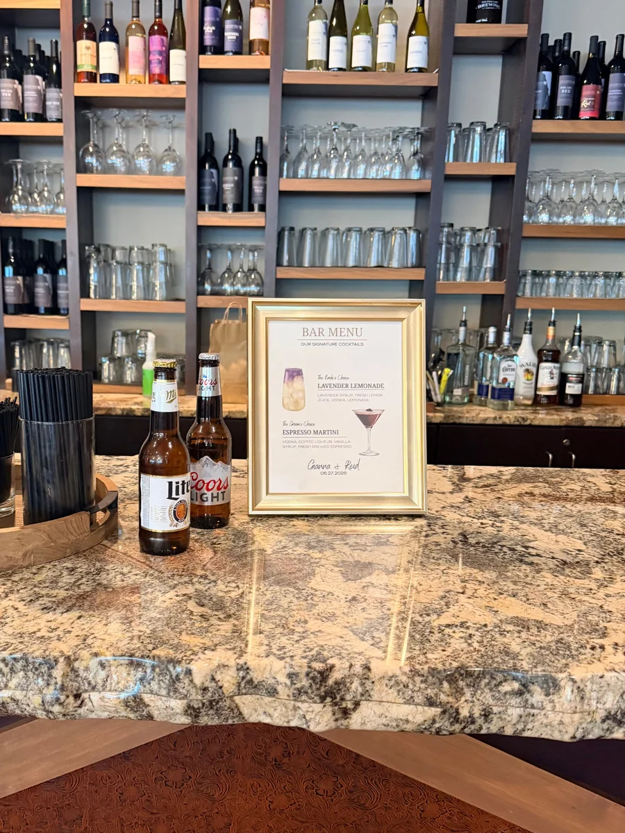 Framed signature drink menu on a granite bar with bottles and glasses behind