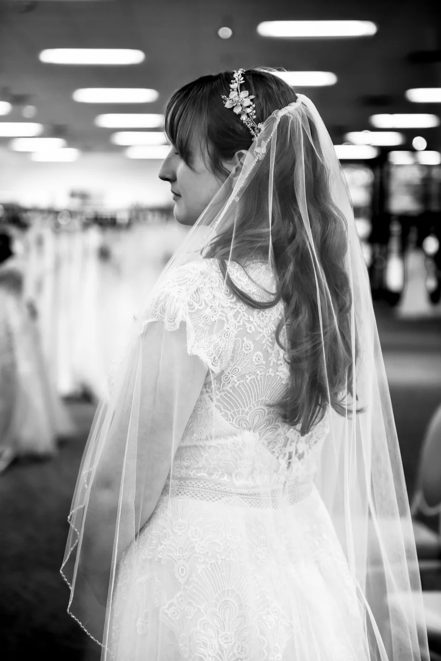 Black and white profile of a bride in a lace veil and beaded hair piece